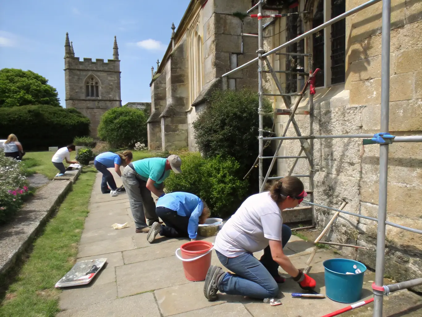A group of volunteers working together to restore a historic stone building in Chaux, showcasing community involvement in heritage preservation.